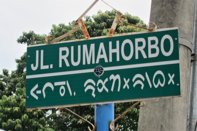 Batak street sign in both Latin and Batak (horizontal) scripts.