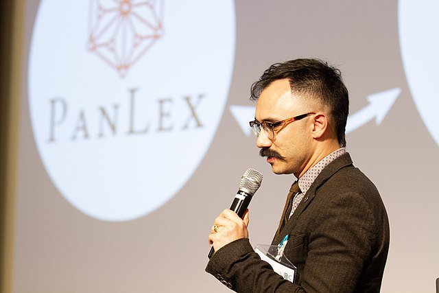 Speaker Ben Yang in front of slide displaying PanLex logo.